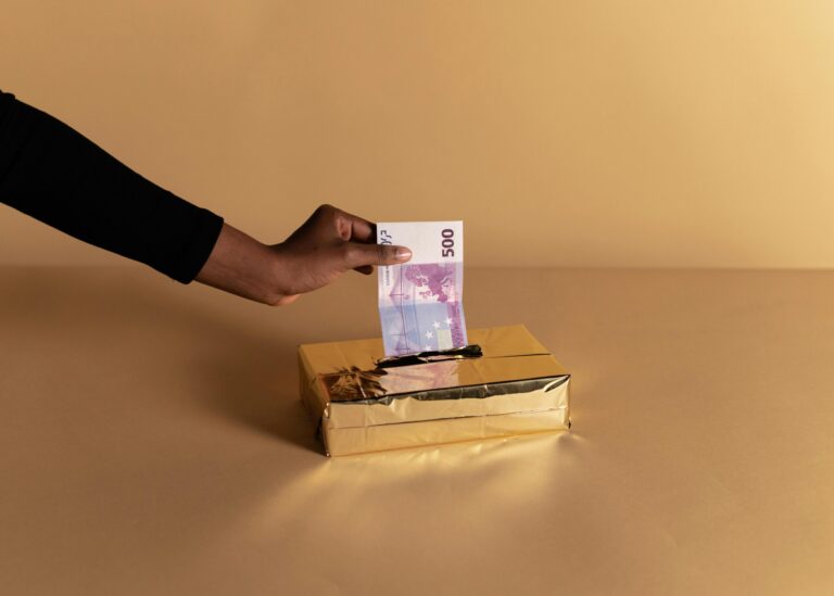Euro banknote held by a hand against beige background, symbolizing bribery or gifting.